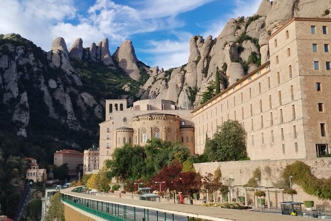 The abbey at Montserrat tucked under the ridge, pines on the slope beneath