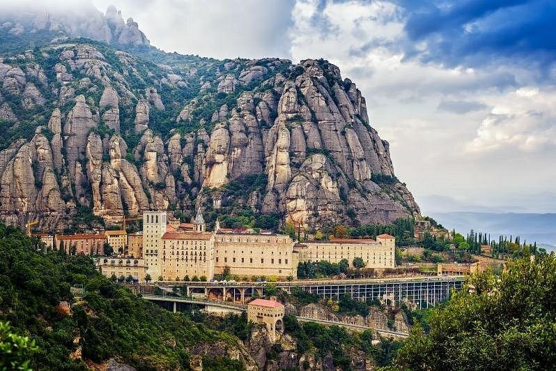 Montserrat monastery seen from the valley below, the ridge rising behind it