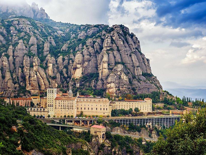 The monastery set into the Montserrat massif, the road climbing towards it